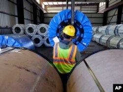 In this Nov. 21, 2016 photo, a worker uses a lift to move rolls of sheet metal at LMS International, in Laredo, Texas. Donald Trump’s campaign promise to abandon the North American Free Trade Agreement helped win over Rust Belt voters who felt left behind.