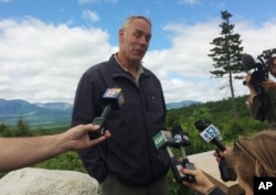 FILE - Interior Secretary Ryan Zinke talks with reporters with part of Mount Katahdin in the background at the Katahdin Woods and Waters National Monument near Staceyville, Maine, June 14, 2017.