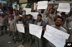 Pakistani civil society activists protest against the rape and killing of a young girl, in Karachi, Pakistan, Jan. 10, 2018. Placard at bottom center reads" remove the incompetent rulers."