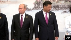 Russian President Vladimir Putin, left, and Chinese President Xi Jinping line up for a photo during the BRICS Summit in southeastern China's Fujian province, Sept. 4, 2017.