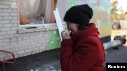 Seorang perempuan menangis setelah sebuah sekolah taman kanak-kanak terkena serangan bom di Svatove, Luhansk, Ukraina timur (foto: dok).