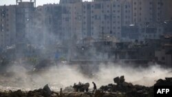 ชายปาเลสไตน์ค้นหาข้าวของในกองขยะบนซากปรักหักพังใน อัล-บูเรอิจ ทางตอนกลางกาซ่า เมื่อ 2 มิถุนายน 2024 ท่ามกลางสงครามอิสราเอล-ฮามาส ที่ดำเนินอยู่ (Photo by Eyad BABA / AFP)