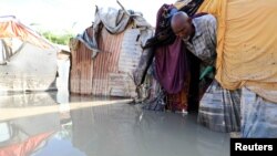 A Somali man walks out of his flooded makeshift shelter after heavy rain in Mogadishu, Somalia October 21, 2019. 