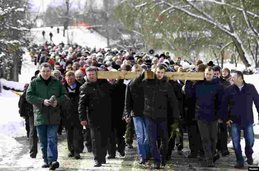 Belarussian Catholics carry a wooden cross as they take part in a procession celebrating Palm Sunday in the town of Oshmiany.