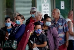 FILE - People line up outside a Kentucky Career Center hoping to find assistance with their unemployment claim in Frankfort, Kentucky, June 18, 2020.