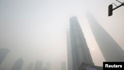 An electronic screen and buildings are seen amid heavy smog at the financial district of Pudong in Shanghai, Dec. 6, 2013.
