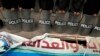 Egyptian anti-riot soldiers guard a destroyed Muslim Brotherhood party banner after protestors broke into party offices in a Cairo neighborhood on March 22, 2013. (AP)