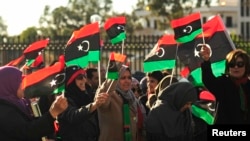 Perempuan Libya ikut berpawai keliling kota dengan membawa bendera negaranya dalam perayaan dua tahun revolusi di Benghazi, 17 Februari 2013. (REUTERS/Esam Al-Fetori).