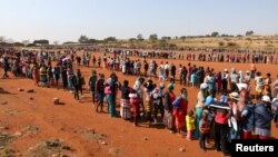 Warga antre bantuan makanan di tengah merebaknya pandemi virus corona di permukiman Itireleng, dekat pinggiran Laudium di Pretoria, Afrika Selatan, 20 Mei 2020. 