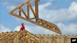 FILE - A construction worker builds a commercial complex in Springfield, Illinois.
