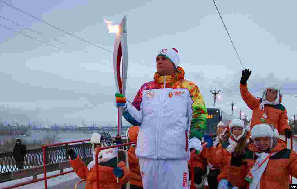 Pembawa Obor Olimpiade Musim Dingin Sochi 2014 ketika melalui ibukota Moskow, Rusia. 