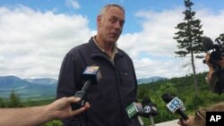 FILE - Interior Secretary Ryan Zinke talks with reporters with part of Mount Katahdin in the background at the Katahdin Woods and Waters National Monument near Staceyville, Maine, June 14, 2017.