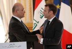 French president Emmanuel Macron, right, shakes hands with Iraqi President Barham Saleh after a press conference at the Elysee Palace in Paris, Feb. 25, 2019. Saleh is on a two-day visit to France.