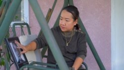 Nirada Kunarakkij (นิรดา คุณารักษ์กิจ) cleans her mother's portrait during an interview with VOA Thai.