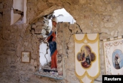 A Virgin Mary statue is seen in cemetery following an earthquake at Sant' Angelo near Amatrice, central Italy, Aug. 26, 2016.