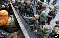One of the military's first battalions to be deployed in the city of Marawi board a military truck as they arrive to a hero's welcome at Villamor Air Base, Oct. 20, 2017, in Pasay city, southeast of Manila, Philippines.