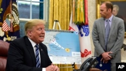President Donald Trump, left, talks about Hurricane Florence during a briefing in the Oval Office of the White House in Washington, Tuesday, Sept. 11, 2018, as FEMA Administrator Brock Long listens at right. (AP Photo/Susan Walsh)