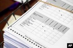 FILE - Ballots are prepared for recounting in Maine's 2nd Congressional District, Dec. 6, 2018, in Augusta, Maine.
