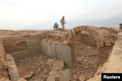 A member of the Iraqi army walks around the remains of wall panels and colossal statues of winged bulls, destroyed by Islamic State militants in the Assyrian city of Nimrud, south of Mosul, Iraq, Nov. 16, 2016.