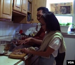 Artharini dan suami sedang sibuk menyiapkan pesanan di dapur rumah mereka di Maryland.