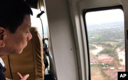 FILE - Philippine President Rodrigo Duterte looks at damage after Tropical Storm Kai-Tak hit the island province of Biliran, central Philippines, Dec. 18, 2017.