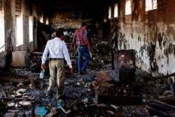 Workers walk in a damaged hall at the National Museum in the southwestern city of Taiz, Yemen May 26, 2021. (REUTERS/Anees Mahyoub)