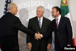 U.S. Secretary of State Rex Tillerson (center) looks at Secretary of Homeland Security John Kelly as he shakes hands with Mexico's Foreign Secretary Luis Videgaray (right) after delivering statements at the Ministry of Foreign Affairs in Mexico City, Feb. 23, 2017.