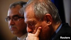 Cyprus Central Bank Governor Panicos Demetriades (L) and Cypriot Finance Minister Michael Sarris listens to reporters' questions during a news conference in the building of the Central Bank of Cyprus, in Nicosia, March 26, 2013.