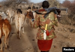 FILE - A Turkana tribesman carries his gun in order to protect his cattle from rival Pokot and Samburu tribesmen near Baragoy, Kenya February 13, 2017.