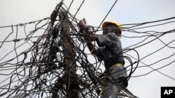 Nigeria Power employee works on a tangle of lines, Lagos, July 22, 2011.