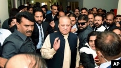 FILE - In this photo released by Pakistan Muslim League, Pakistani deposed Prime Minister Nawaz Sharif, center, arrives at an anti-corruption court in Islamabad, Pakistan, Sept. 26, 2017.