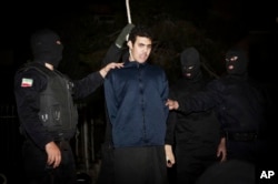 FILE - Iranian police prepare to hang a young convict in Tehran, Jan. 20, 2013.