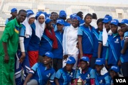 The Basic College high school all-girl rugby team smiles at the end of the tournament. They played a scoreless game, but they still received a trophy. (VOA / C. Oduah)