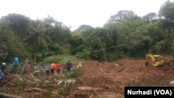 Upaya pencarian 2 korban tanah longsor dibantu alat berat. (Foto:VOA/Nurhadi)