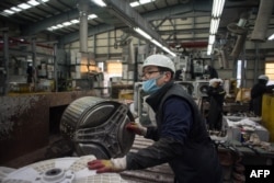 한국 용인의 재활용센터 직원이 세탁기를 해체하고 있다.