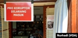 Sebuah poster dipasang oleh para aktivis anti korupsi di pintu masuk Pukat UGM. (Foto:VOA/Nurhadi)
