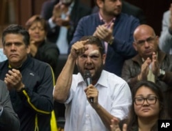 FILE - Opposition lawmaker Juan Requesens, center, speaks at the National Assembly during a session in Caracas, Venezuela, April 5, 2017. President Nicolas Maduro on Aug. 7, 2018, accused Requesens and another opposition legislator of having roles in the drone explosions that Venezuelan officials have called an assassination attempt against him.