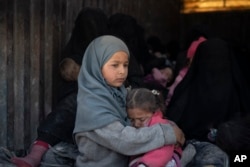 Children ride in the back of a truck that is part of a convoy evacuating hundreds out of the last territory held by Islamic State militants, in Baghuz, eastern Syria, Feb. 20, 2019.