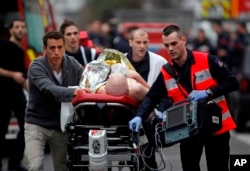 An injured person is evacuated outside the French satirical newspaper Charlie Hebdo's office, in Paris, Jan. 7, 2015.