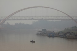 Seorang pria memancing saat kabut asap menutupi sungai Kahayan di Palangka Raya, Provinsi Kalimantan Tengah, 17 September 2019. (Foto: REUTERS/Willy Kurniawan)