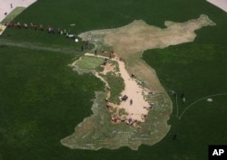 Radnici sade cveće u oblik Korejskog poluostrva u znak želje za uspešnom interkorejskom samitu u Seul plazi u Seulu, Južna Koreja, 13. aprila 2018. Severnokorejski lider Kim Džong Un sastaće se sa južnokorejskim predsednikom Mun Đae Inom 27. aprila na granici.