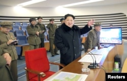 North Korean leader Kim Jong Un (C) reacts as he watches a long range rocket launch in North Korea, in this photo released by Kyodo February 7, 2016.