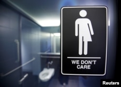 A sign protesting a recent North Carolina law restricting transgender bathroom access adorns the bathroom stalls at the 21C Museum Hotel in Durham, North Carolina, May 3, 2016.