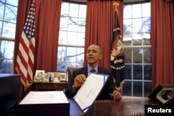 U.S. President Barack Obama reacts as after signing the $1.1 Trillion Government Funding Bill into Law at the Oval Office of the White House in Washington, Dec. 18, 2015.