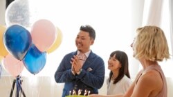 FILE - Marie Kondo, center, looks on as a cake is brought to celebrate her husband Takumi Kawahara's birthday in New York, Wednesday, July 11, 2018. (AP Photo/Seth Wenig)