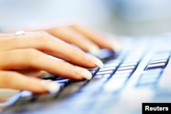 FILE - A woman uses a computer keyboard in this photo illustration taken in Sydney, Australia, June 23, 2011.