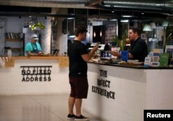 Chef Mario melayani seorang pelanggan yang membeli bumbu dari cacing mopane di Restoran Insect Experience di Cape Town, Afrika Selatan, 23 Agustus 2019. (Foto: Reuters)