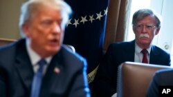 FILE - National security adviser John Bolton listens as President Donald Trump speaks during a cabinet meeting at the White House in Washington, April 9, 2018.