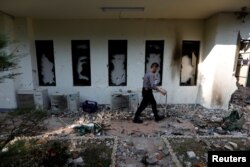 Seorang polisi berjalan melintas jendela yang rusak dalam kerusuhan yang terjadi setelah pengumuman hasil resmi pilpres di Badan Pengawas Pemilu (Bawaslu) di Jakarta, 23 Mei 2019.