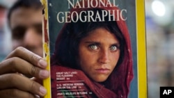 Seorang penjual di Islamabad, Pakistan, memperlihatkan sebuah majalah National Geographic yang menampilkan foto Sharbat Gulla yang menjadi ikon majalah tersebut, 26 Oktober 2016. (Foto: dok).